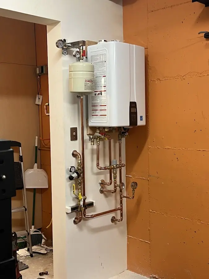 Plumbing technician inspecting water heater connections in Fairmont